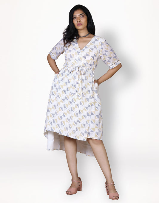 Front view of Hueloom's convertible wrap dress in white with kolam print and pockets on both sides.