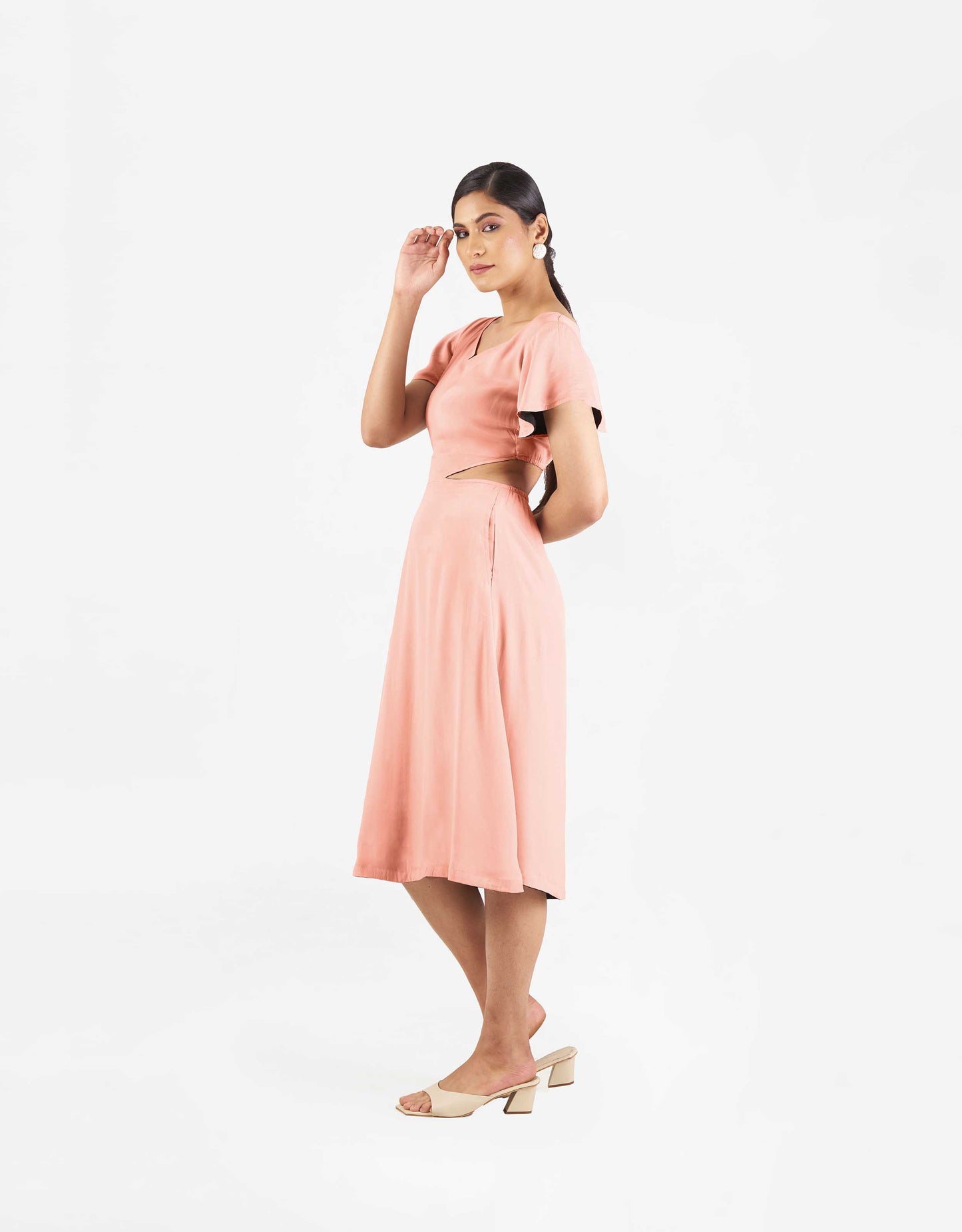 Side view of Hueloom's Reversible Cut-out dress in coral.