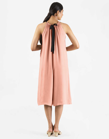 Back view of Hueloom's Reversible jumpsuit in coral.