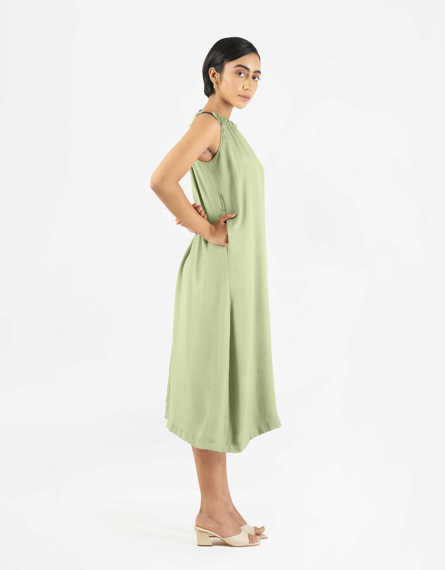Side view of Hueloom's Reversible jumpsuit in mint green with pockets.