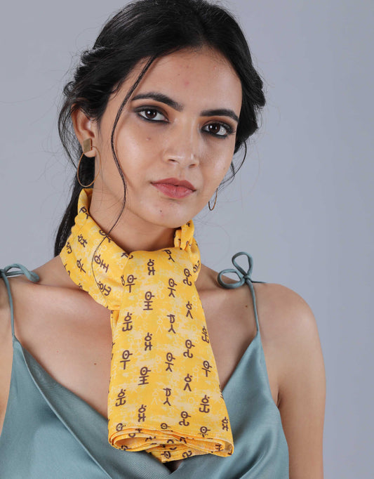 Hueloom's yellow brahmi printed bandeau scarf around neck.